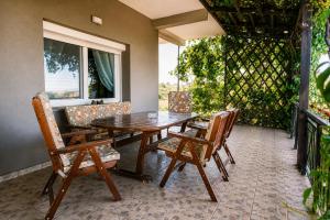 a wooden table and chairs on a patio at Hill View 4 in Alexandroupoli