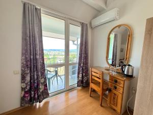 a room with a mirror and a dresser and a window at Guest House Orfey in Kranevo