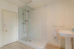 a white bathroom with a shower and a sink at 4 Bed in Lyndhurst oc-57407 in Lyndhurst +19 photos