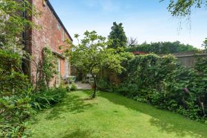 a garden with a brick building and a yard at 4 Bed in Lyndhurst oc-57407 in Lyndhurst