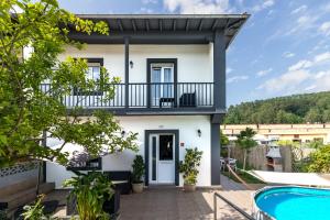 a white house with a balcony and a swimming pool at Casa independiente entre mar y montaña in Puente San Miguel