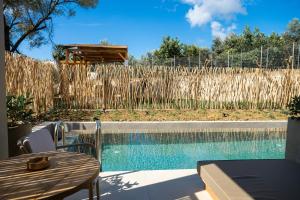 ein Pool im Garten mit Tisch und Zaun in der Unterkunft Seagonia in Pogoniá