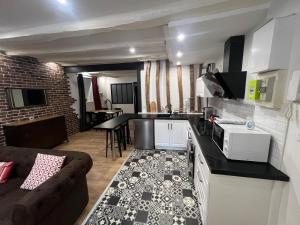 a kitchen and living room with a couch and a table at Appartement Limoges in Limoges