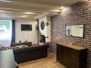 a living room with a couch and a brick wall at Appartement Limoges in Limoges