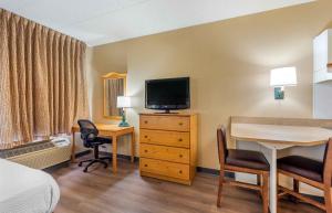 a hotel room with a bed and a desk with a television at Extended Stay America Select Suites - Chicago - Lombard - Oakbrook in Oakbrook Terrace