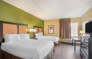 a hotel room with two beds and a flat screen tv at Extended Stay America Select Suites - Chicago - Lombard - Oakbrook in Oakbrook Terrace +46 photos