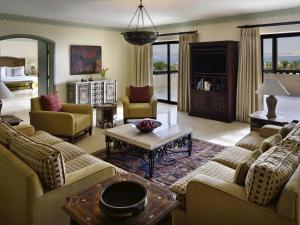 a large living room with couches and a tv at Mövenpick Resort & Spa Dead Sea in Sowayma