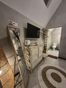 a living room with a tv on top of a dresser at Mulyanus Hotel by Calli Rooms in Wirolegi