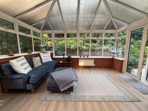 a living room with a couch and some windows at Ivy House in Stockbridge
