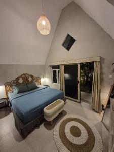 a bedroom with a king sized bed and a rug at Mulyanus Hotel by Calli Rooms in Wirolegi