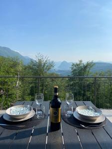 a table with a bottle of wine and glasses on it at Casa Cristina - Stunning Lake & Mountain View in Roveredo Capriasca