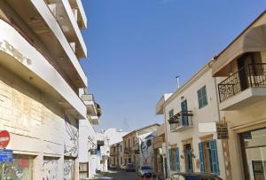 a street in a city with buildings and a car at Central Comfort Studio in Larnaca