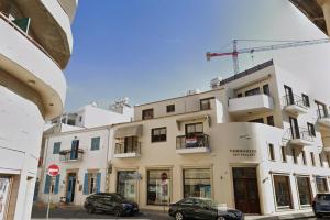 a building with two cars parked in front of it at Central Comfort Studio in Larnaca