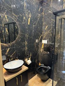 a black marble bathroom with a toilet and a sink at Kontrabanda - Bar & Noclegi in Ustrzyki Górne