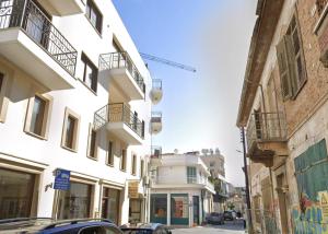 a street with buildings and a car parked on the street at Central Comfort Studio in Larnaca +2 photos