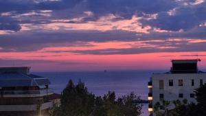a sunset over the ocean with buildings and a building at Greto al Mare in Francavilla al Mare +10 photos