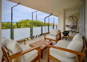 a balcony with white chairs and a table and some windows at Greto al Mare in Francavilla al Mare