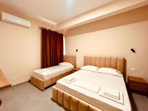 a hotel room with two beds and a window at Kristian apartments in Berat