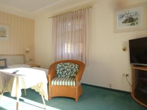 ein Hotelzimmer mit einem Stuhl und einem TV in der Unterkunft Pension Grünauhof in Grünau im Almtal