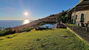 a house with a yard with a view of the ocean at Villa Flora Calheta Sunset & Ocean Views in Jardim do Mar