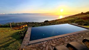 a swimming pool with a view of the ocean at Villa Flora Calheta Sunset & Ocean Views in Jardim do Mar