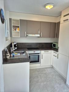 a kitchen with white cabinets and a sink at Alpine Bliss Studio in Wilderswil
