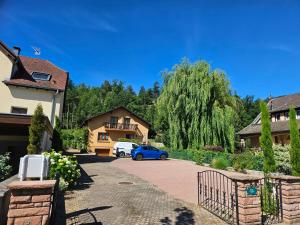 a house with a blue car parked in a driveway at la Parenthèse Kaysersberg in Kaysersberg