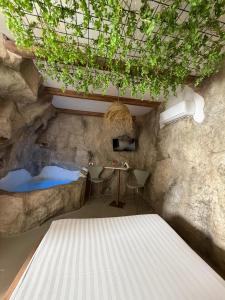 a room with a rock wall with a table and a sink at EmmejSuite in Pozzuoli