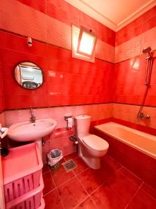 a red bathroom with a toilet and a sink at Ira Hostel in Dahab +50 photos