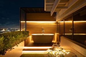 a bathroom with a tub on a balcony at night at Grand China Bangkok in Bangkok +20 photos