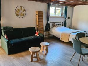 a bedroom with a couch and a bed and a table at la Parenthèse Kaysersberg in Kaysersberg