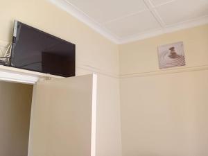 a flat screen tv on top of a white wall at Faranie Guesthouse in Oudtshoorn
