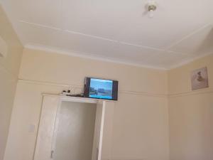 a flat screen tv sitting on top of a wall at Faranie Guesthouse in Oudtshoorn +32 photos