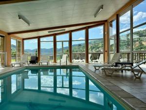 a swimming pool with a view of the mountains at Hôtel Restaurant & Bien-être Le Chalet des Roches in La Bresse