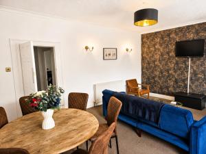 a living room with a blue couch and a table at The Flat in central Kirkby Stephen in Kirkby Stephen