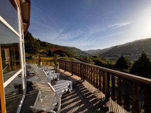 a row of white chairs sitting on a balcony at Hôtel Restaurant & Bien-être Le Chalet des Roches in La Bresse