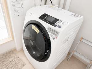 a white washing machine sitting in a room at Yume House in Furano