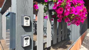 a wall with two toilet boxes on a building with flowers at Ežerėlių sodyba in Ažuluokesa