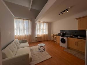 a living room with a white couch and a kitchen at Cosy 2 Story Home Leicester City Centre in Leicester