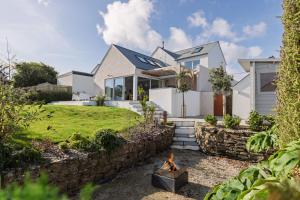 a house with a stone wall and a fire pit at Brennik House in Port Isaac