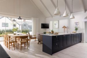 a kitchen and dining room with a table and chairs at Brennik House in Port Isaac