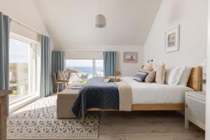 a bedroom with a large bed and a large window at Brennik House in Port Isaac