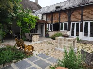a patio with a bench in front of a house at Maison de campagne in Amponville +2 photos
