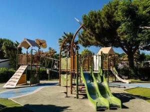 a playground with a slide in a park at Mobil Home SIBLU VALRAS PLAGE in Sérignan