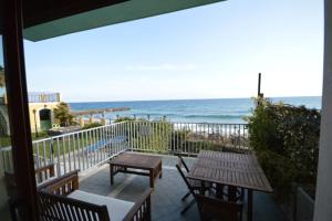 balkon ze stołem i krzesłami oraz oceanem w obiekcie Riva Beach Apartment w mieście Riva Ligure