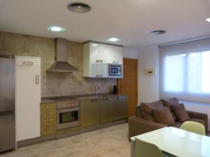 a living room with a couch and a kitchen at Puerta de Ordesa Garden in Laspuña