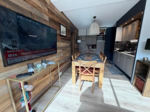 a dining room with a table and a kitchen at Mimi lodge familly in Valloire