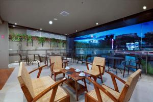 a restaurant with tables and chairs and a large window at favehotel Margonda in Depok