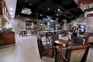 a restaurant with tables and chairs and a bar at favehotel Margonda in Depok