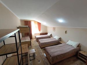 a small room with two beds and a table at Любимый in Cholpon-Ata